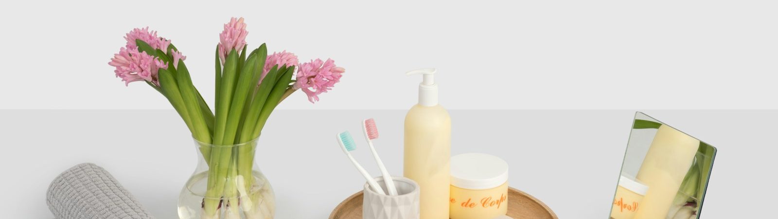 clear glass flower vase near rolled grey mat